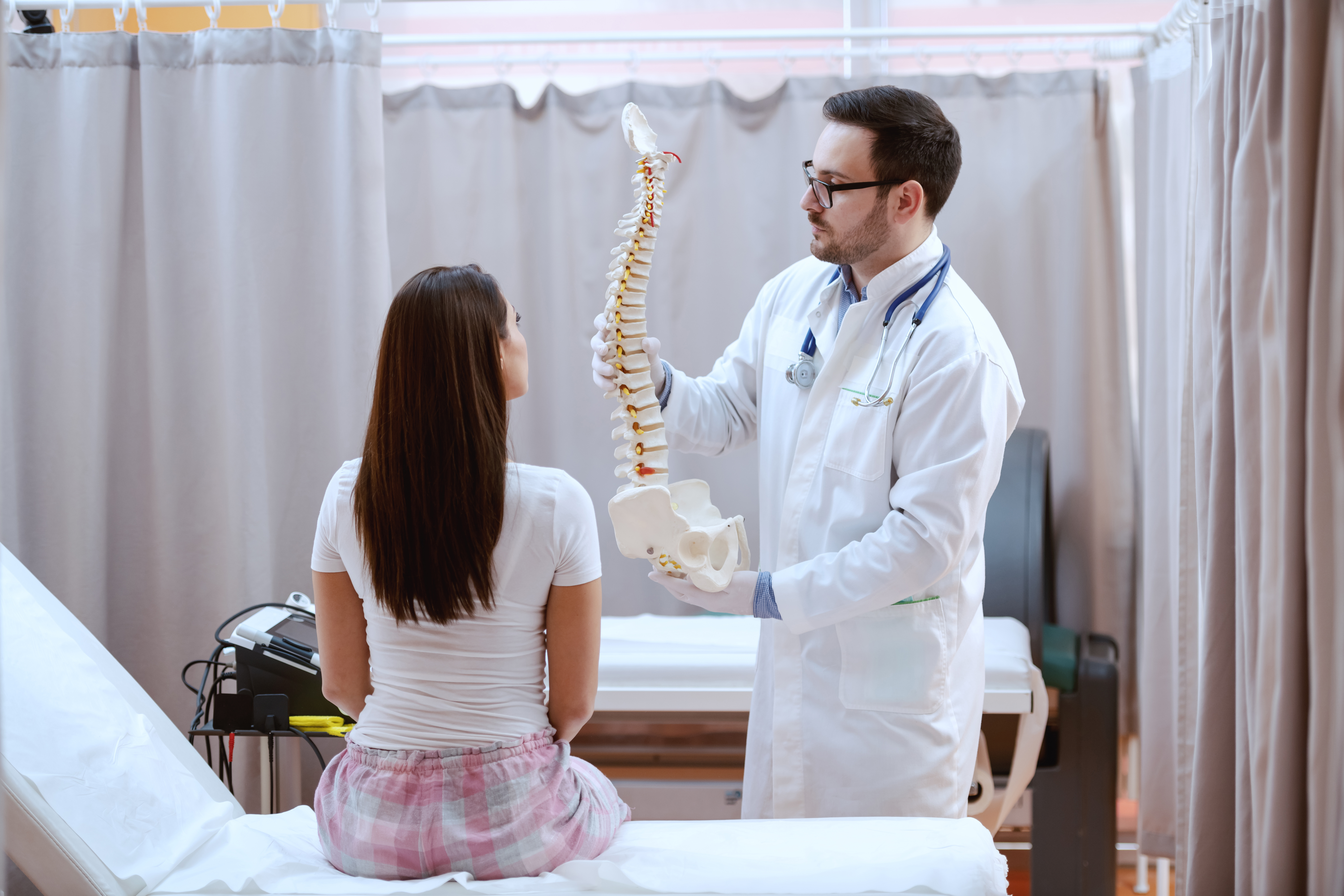 spine model and showing to his patient.