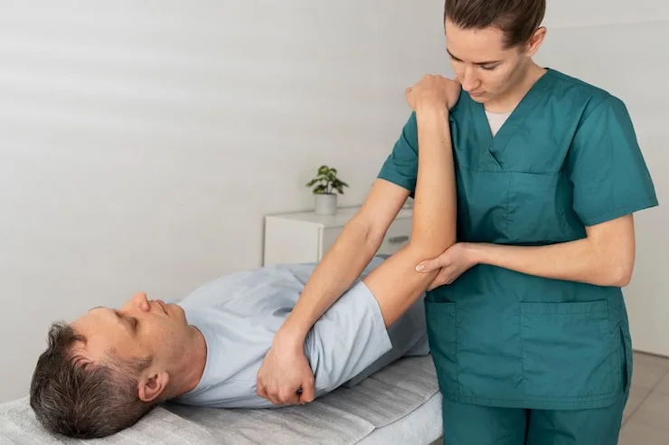 Healthcare professional performing a shoulder mobility assessment on a patient during a physical therapy session.